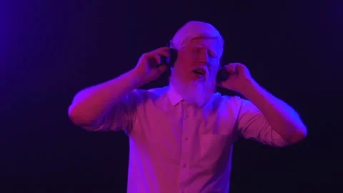 An old albino grandpa dancing while wearing new earphones, isolated on a uniq Stock Footage 137515633