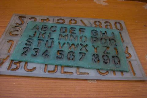 Old alphabet ruler placed on brown table Stock Photos