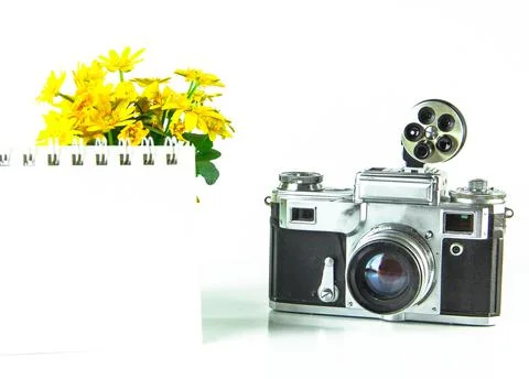 Old analog camera top view with a photo frame and a bouquet of flowers. Stock Photos