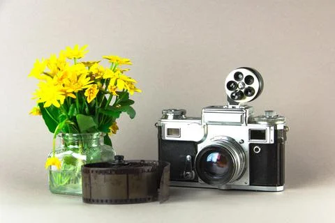 Old analog camera top view with a photo frame and a bouquet of flowers. 写真素材
