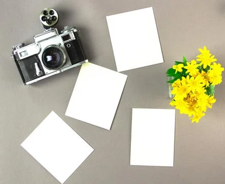 Old analog camera top view with a photo frame and a bouquet of flowers. Stock Photos