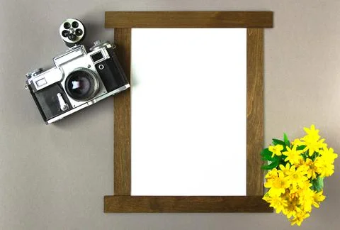 Old analog camera top view with a photo frame and a bouquet of flowers. Stock Photos