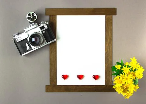 Old analog camera top view with a photo frame and a bouquet of flowers. Stock Photos