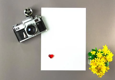 Old analog camera top view with a photo frame and a bouquet of flowers. Stock Photos