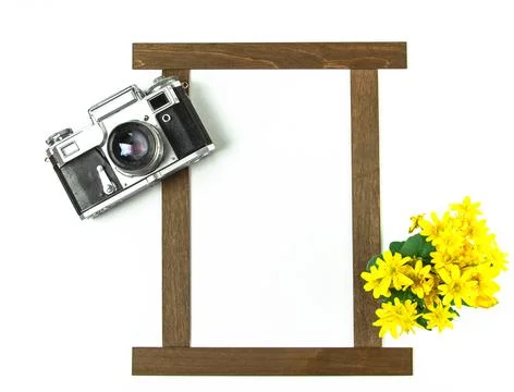Old analog camera top view with a photo frame and a bouquet of flowers. Stock Photos