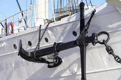 An old anchor strapped to the side of the ship Stock Photos