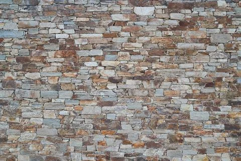 Old ancient stone wall background of medieval house brick horizontal stones w Stock Photos