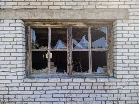 Old and broken window of a brick and abandoned building Foto stock