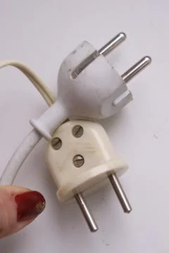 Old and new electrical plug hold hand Stock-Fotos