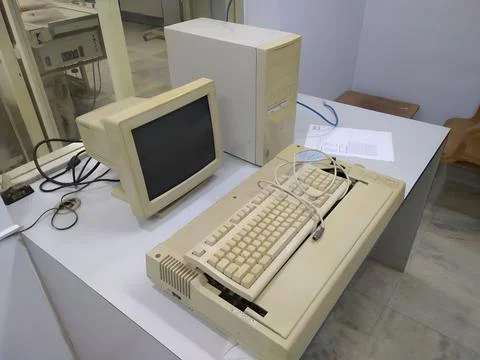 Old and obsolete computer on old wood table with concrete wall background Stock Photos