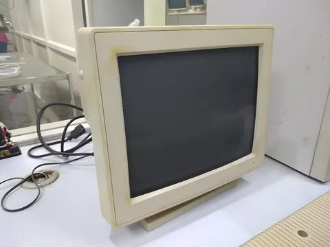 Old and obsolete computer on old wood table with concrete wall background Stock Photos