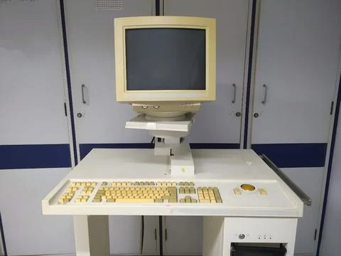Old and obsolete computer on old wood table with concrete wall background Stock Photos