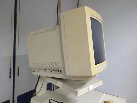 Old and obsolete computer on old wood table with concrete wall background Foto stock