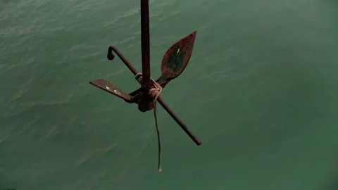 Old and rust ship anchor oscillating in green water Vidéo 133415467