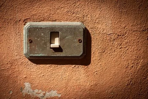 Old and rusty Light Switch on a red wall - Liguria Italy Stock Photos