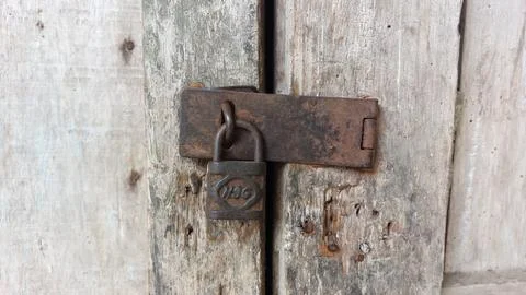 An old and rusty padlock key to secure the door of an old house Stock Photos