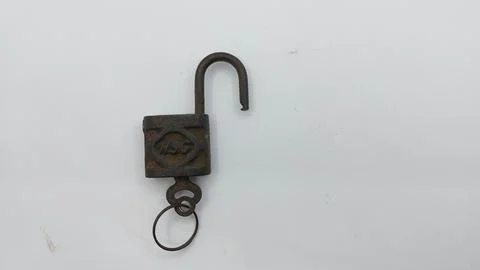 An old and rusty padlock key for securing a house door on a white background Stock Photos