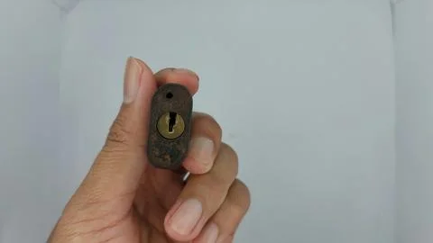 An old and rusty padlock key for securing a house door on a white background Stock Photos
