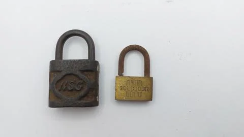 An old and rusty padlock key for securing a house door on a white background Stock Photos