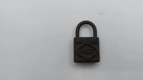 An old and rusty padlock key for securing a house door on a white background Stock Photos