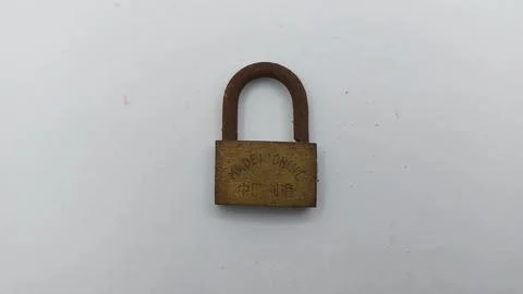 An old and rusty padlock key for securing a house door on a white background Stock Photos