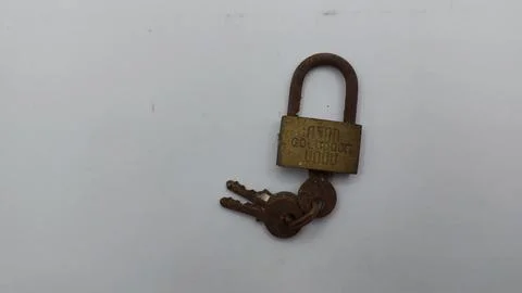 An old and rusty padlock key for securing a house door on a white background Stock Photos