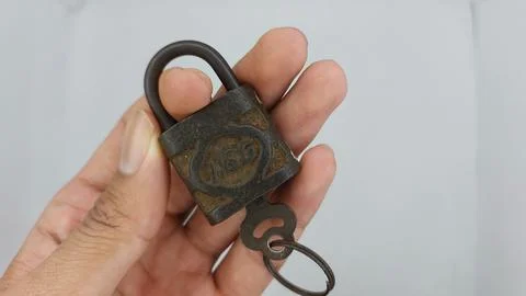 An old and rusty padlock key for securing a house door on a white background Stock Photos