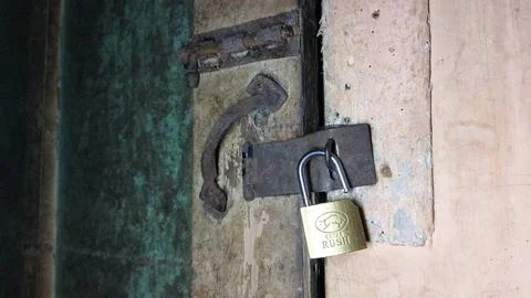 An old and rusty padlock key to secure the door of an old house Stock-Fotos