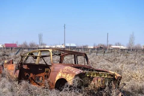 Old and rusty Soviet made car in dry hay in rural seting Stock Photos