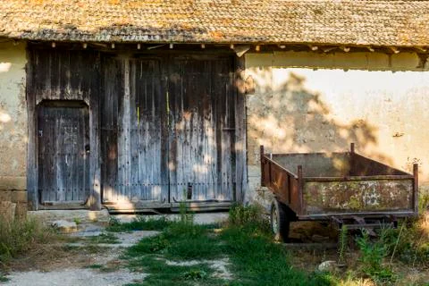 Old and rusty trailer in front of a abandoned farm. Stock Photos