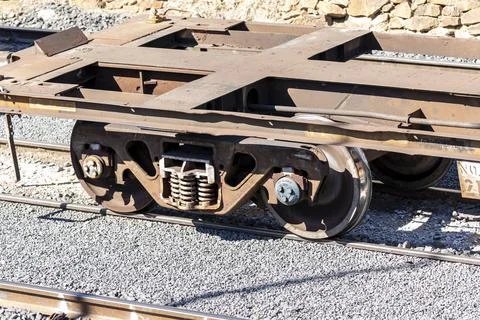 Old and rusty train wheels on a flat bed carriage Stock Photos
