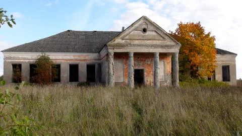 Old and soviet destroyed building from the times of the ussr in the field in Fotos Stock