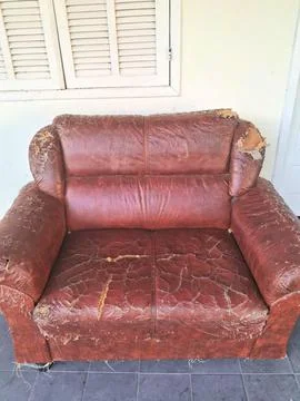 Old and torn leather sofa on the balcony Stock Photos