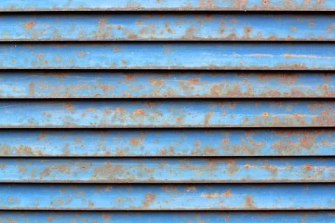 Old and weathered rusty light blue metallic window shutters. Texture for back Stock Photos