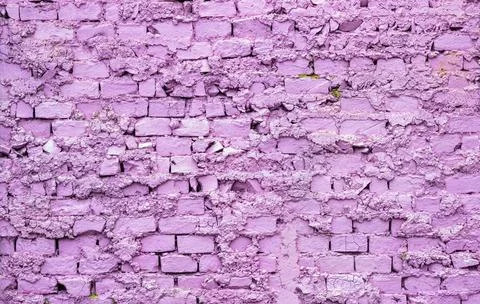 Old and worn brick wall painted in purple Stock Photos