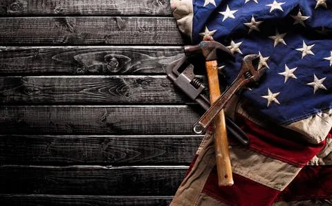 Old and worn work tools on large American flag - Labor day background Stock Photos
