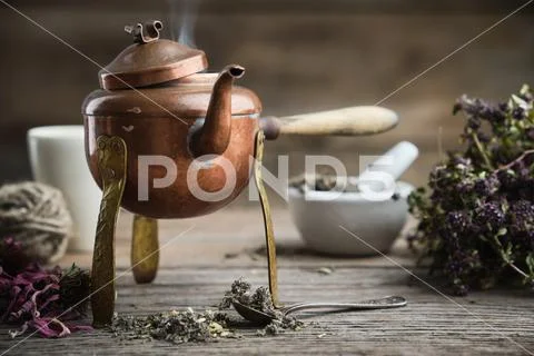 Old antique boiling teapot, mortar, dry coneflowers and thyme bunch. Stock Photos