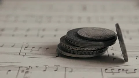 Old antique coins falling on the sheet of music close up, financial money Stock Footage 150564195