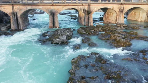 Old arch bridge over blue river flowing through beautiful rocky landscape Stock Footage 211782209