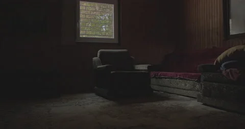 An old armchair in front of the grilled window. Gimbal shot. Mystic, dark room. Stock Footage 158790415