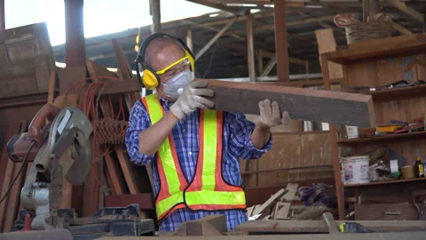 Old asian carpenter looking and checking wood in workshop . senior craftsman Stock Footage 158423616