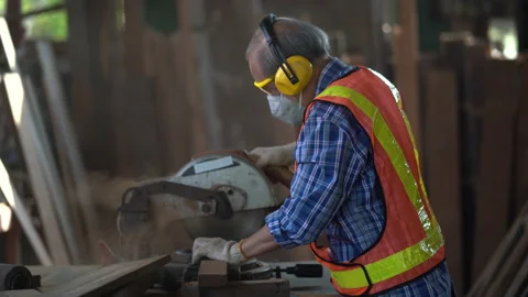 Old asian carpenter using circular saw cutting wooden plank in workshop . You Stock Footage 149984460