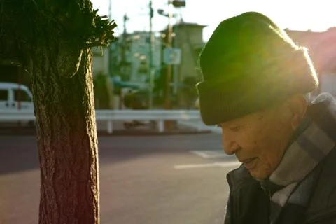 An old Asian man walking down the road in Winter Stock Photos