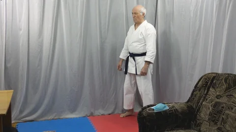 An old athlete is training a circular kick in the quarantine self-isolation Stock Footage 129791006