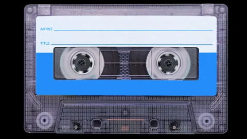 Old audio cassette rotates with transparent shell and blue label on black Stock-Footage 344986848