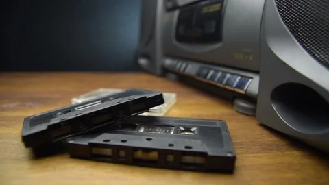 Old audio cassettes and a player on a wooden table Video stock 130970073