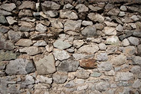 Old background of natural stones of different sizes bonded with cement mortar Stock Photos