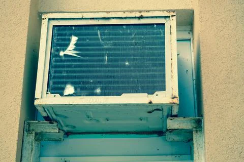 Old bad broken rectangular substandard rusty air conditioner for cooling air  Foto stock