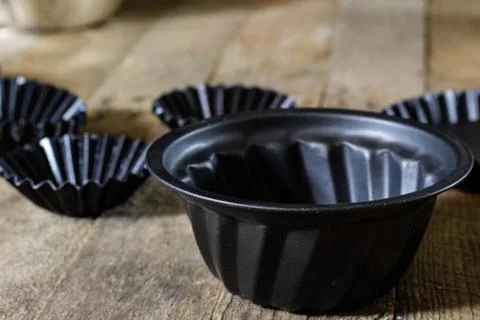 Old baking molds on an old kitchen table. Baking accessories in the kitchen. Stock Photos