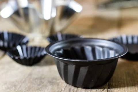 Old baking molds on an old kitchen table. Baking accessories in the kitchen. Stock Photos